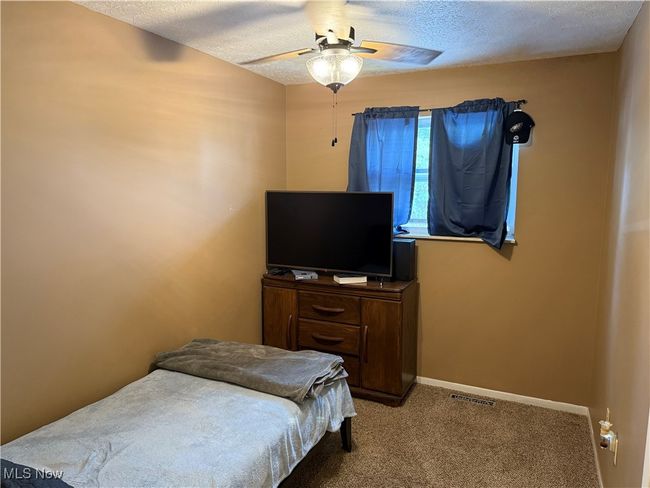 Bedroom featuring visible vents, a ceiling fan, carpet floors, baseboards, and a textured ceiling | Image 13