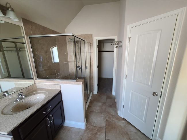 Bathroom with vaulted ceiling, a stall shower, and vanity | Image 17
