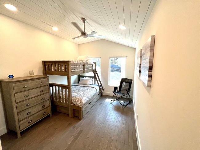 Cozy secondary bedroom with stylish bunk beds, abundant natural light, and a sleek ceiling fan. Perfect for guests or children. | Image 13