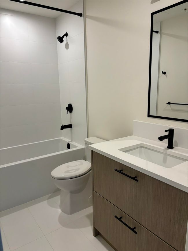 Full bath featuring vanity, washtub / shower combination, and tile patterned flooring | Image 17