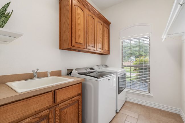 Separate utility room with cabinets galore, deep sink, and rod for hanging clothes! | Image 28