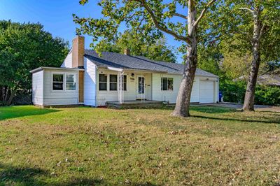 Ranch-style home with a front yard and a garage | Image 2