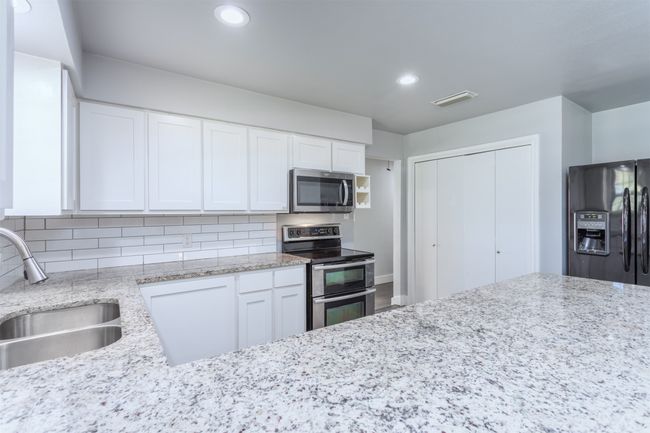 Kitchen with tasteful backsplash, visible vents, stainless steel appliances, and a sink | Image 10