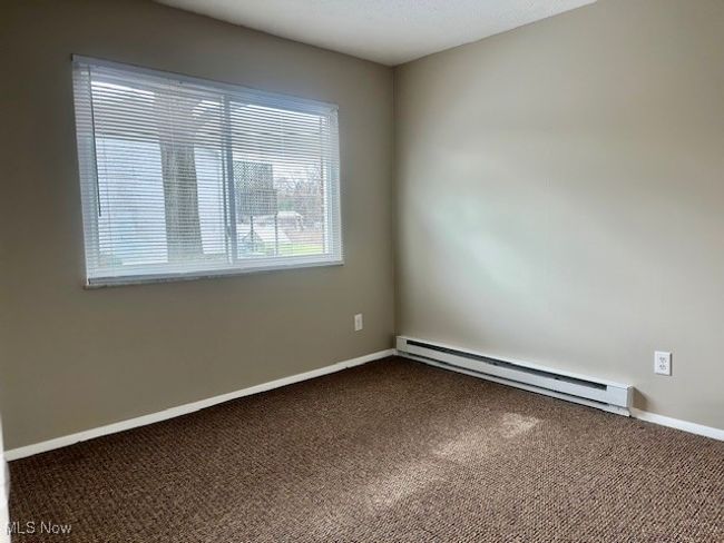 Empty room with baseboards, baseboard heating, and carpet flooring | Image 13
