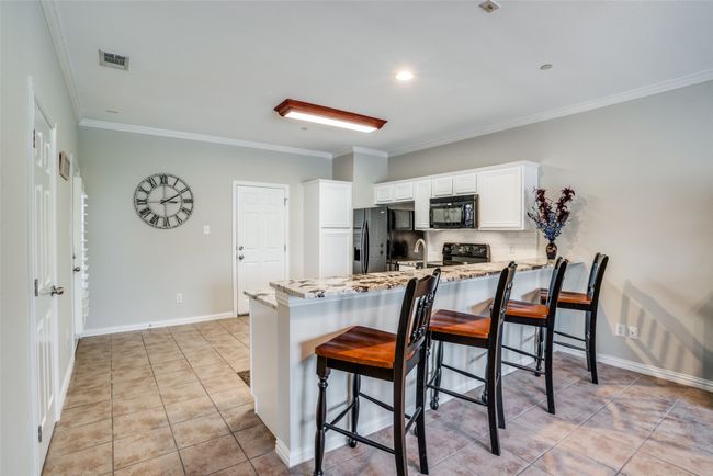 Kitchen, large bar top, powder room, entrances to backyard and garage | Image 6