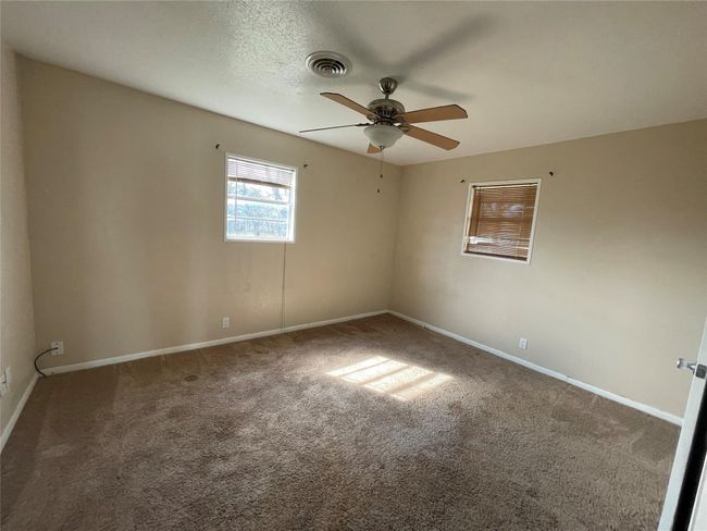 Carpeted empty room featuring a ceiling fan and baseboards | Image 6