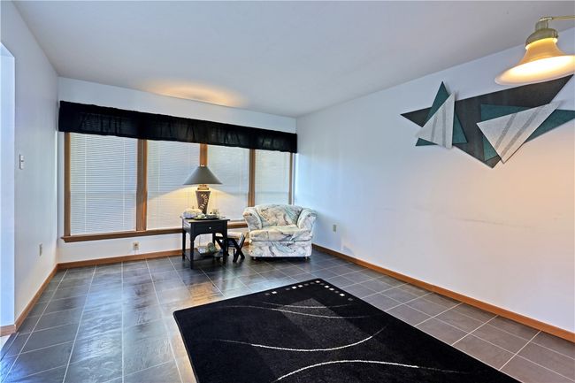 The front wall of the living room is filled with windows. | Image 10