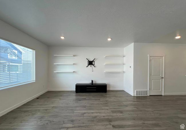 Unfurnished living room with dark wood finished floors, recessed lighting, and a textured ceiling | Image 6