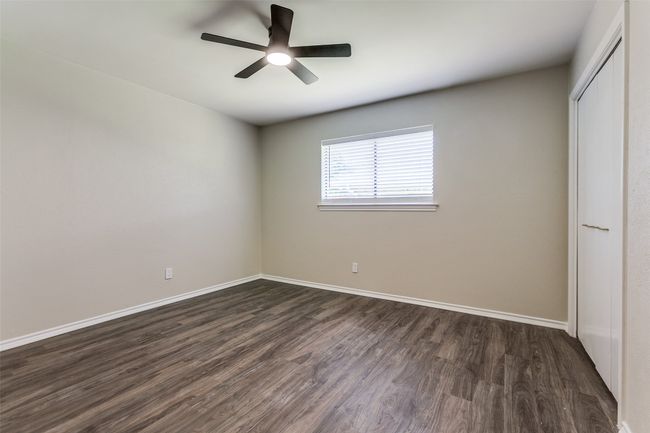 Unfurnished bedroom featuring dark wood-type flooring, a closet, and ceiling fan | Image 22