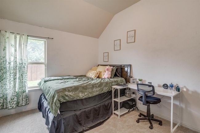 Carpeted bedroom featuring lofted ceiling and a desk | Image 23