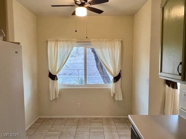 Unfurnished dining area with a ceiling fan, baseboards, and light tile patterned floors | Image 8