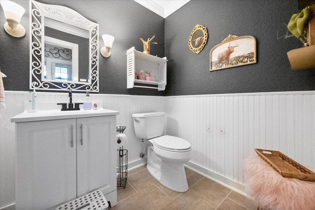 Half bath with toilet, a wainscoted wall, tile patterned flooring, vanity, and baseboards | Image 13