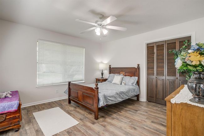 Bedroom with light wood-style flooring, a closet, and a ceiling fan | Image 29