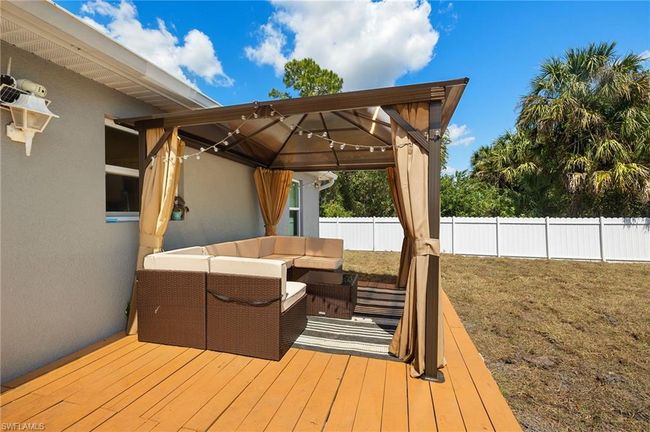 Wooden terrace with a fenced backyard, a gazebo, and outdoor lounge area | Image 22