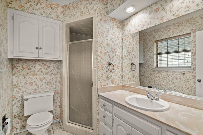 Bathroom featuring tile patterned flooring, vanity, toilet, wallpapered walls, and a stall shower | Image 15