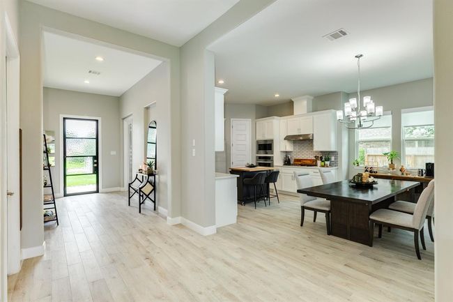 This dining room is bathed in naturallight streaming through expansivewindows. | Image 9