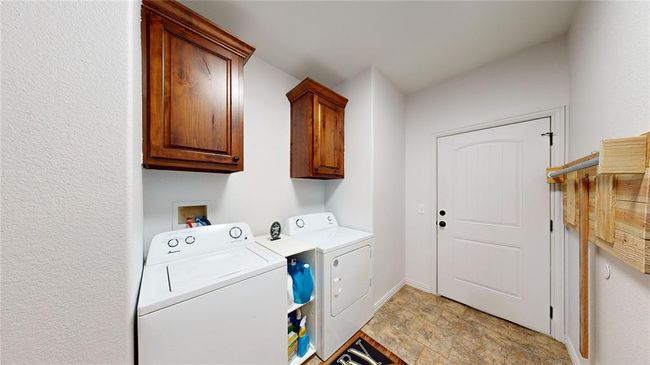 Washroom featuring baseboards, independent washer and dryer, and cabinet space | Image 28