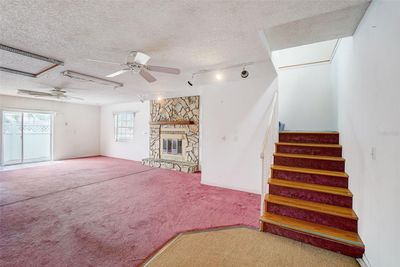 First Floor spacious living room with cozy fireplace, sliders out to the patio, and a convenient laundry room. | Image 3