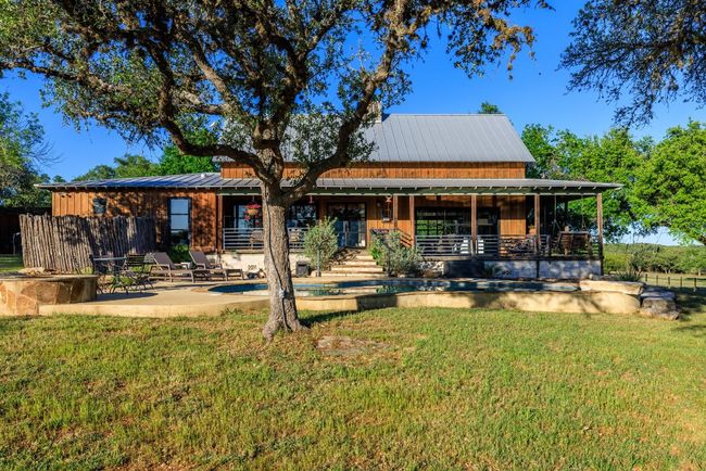 Back of property with a patio, board and batten siding, and a metal roof | Image 11