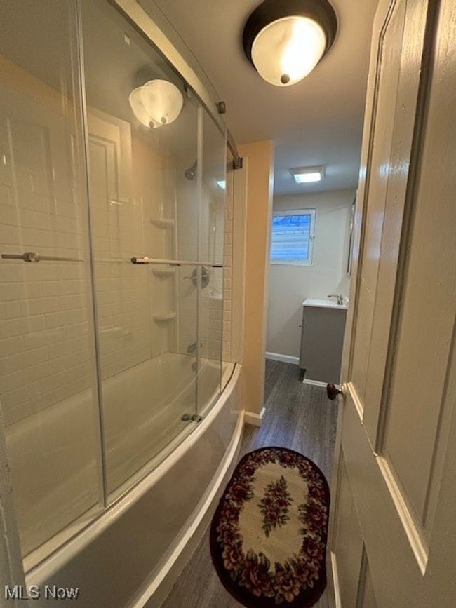 Bathroom featuring combined bath / shower with glass door, vanity, and hardwood / wood-style flooring | Image 12