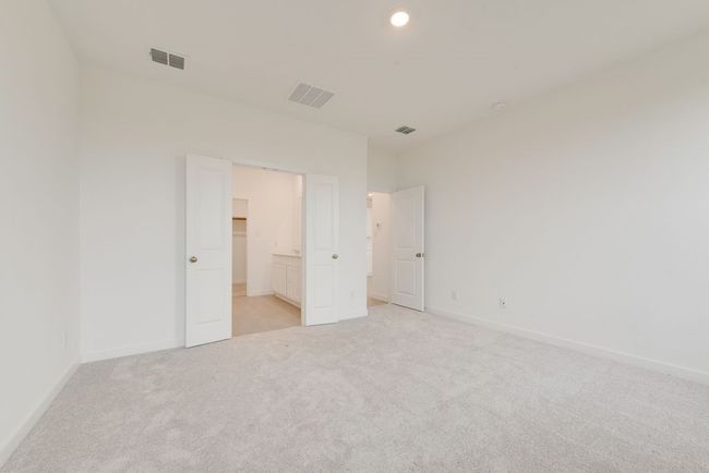 Unfurnished bedroom featuring light carpet, baseboards, a walk in closet, and recessed lighting | Image 20