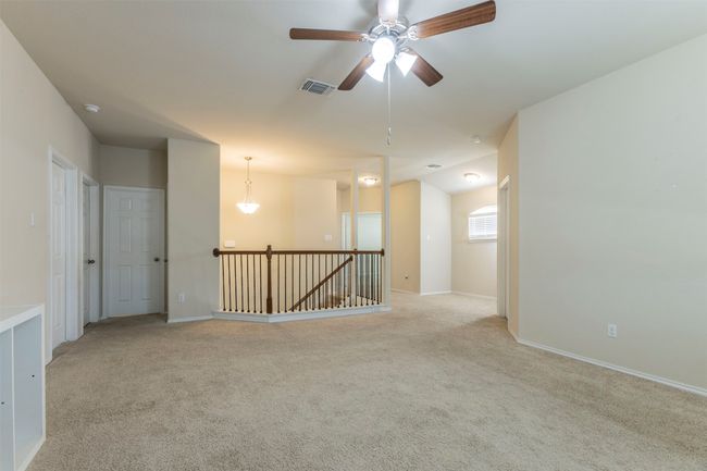 Unfurnished room featuring a ceiling fan, baseboards, visible vents, and light carpet | Image 21