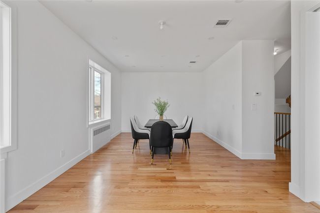 Dining room with radiator, light wood-style flooring, visible vents, and baseboards | Image 15