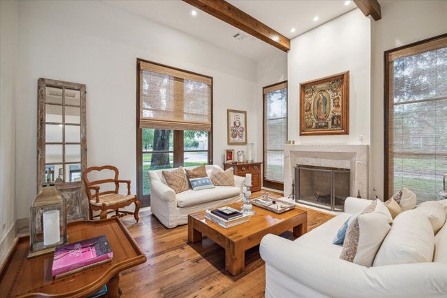 The formal living room with high beamed ceilings, walnut flooring and a masonry woodburning fireplace. | Image 14