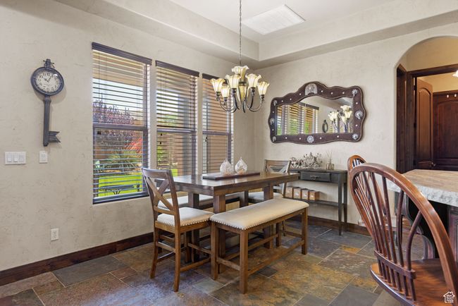 Dining space with stone tile floors, arched walkways, and a chandelier | Image 38