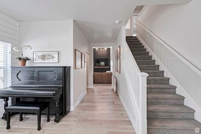 Staircase with wood finished floors and a chandelier | Image 11