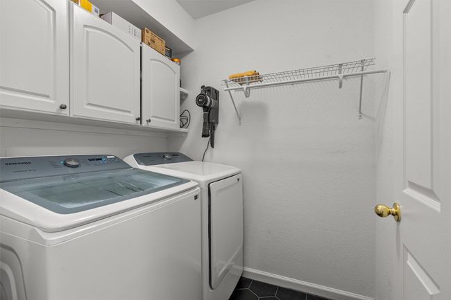 Laundry area with independent washer and dryer, cabinet space, and dark tile patterned floors | Image 29