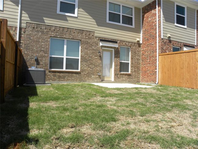 Rear view of property with brick siding, a fenced backyard, and a patio | Image 29