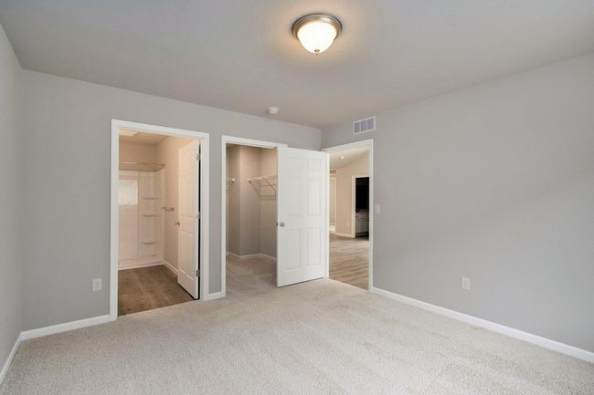 The luxurious primary suite includes a private bath and large walk-in closet. | Image 12