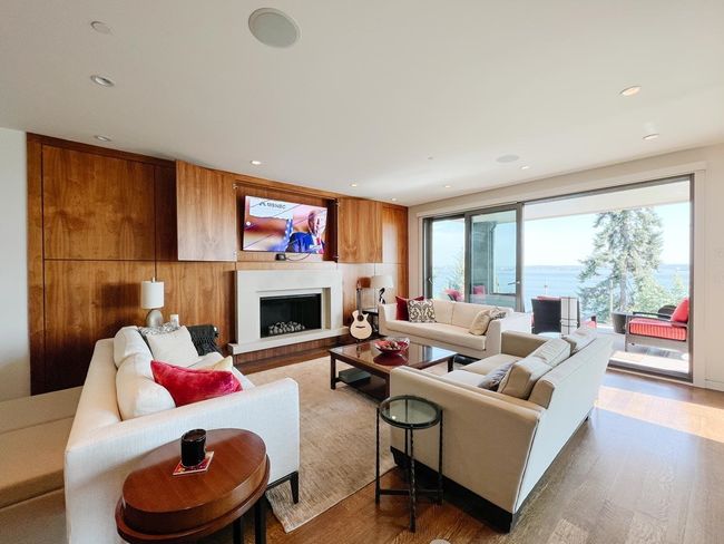 Living area with wood finished floors, a fireplace with raised hearth, and recessed lighting | Image 5