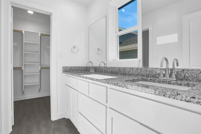 Bathroom with double vanity, a spacious closet, and wood finished floors | Image 8