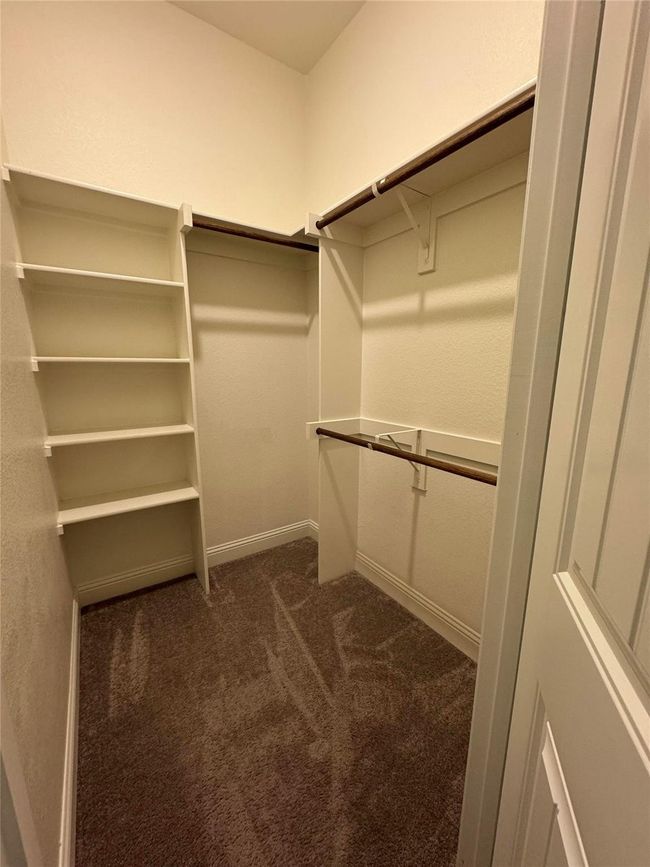 Spacious closet featuring dark colored carpet | Image 36