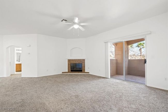 Unfurnished living room with carpet flooring, a ceiling fan, visible vents, and a high end fireplace | Image 10