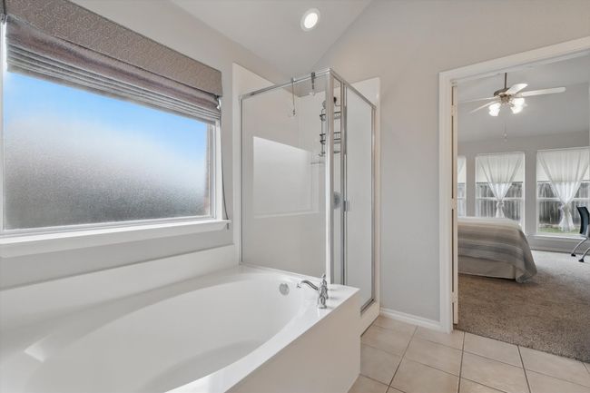 Ensuite bathroom featuring a garden tub, a shower stall, tile patterned floors, baseboards, and connected bathroom | Image 26