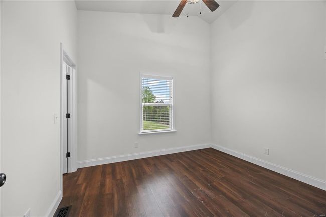 Unfurnished room featuring baseboards, a ceiling fan, and dark wood-style flooring | Image 14