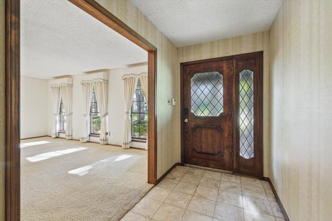 Foyer featuring light colored carpet, baseboards, a textured ceiling, and wallpapered walls | Image 5