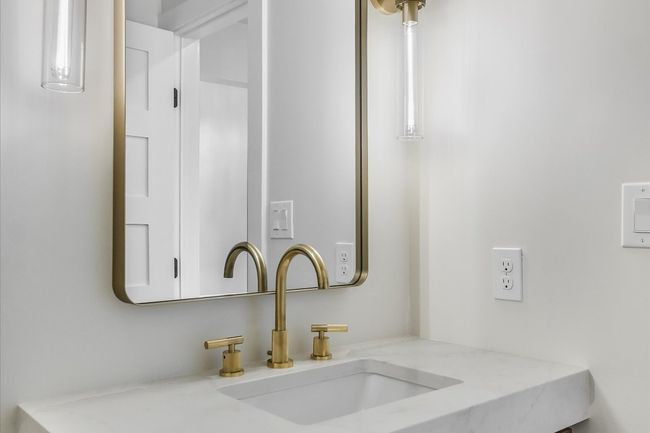 Luxury powder bath with knurled brass light fixture and knurled brass faucet | Image 14