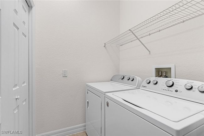 Laundry area with separate washer and dryer and a textured wall | Image 20