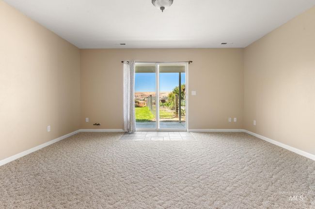 Family room on lower level featuring, arched entry, carpet, sliding glass door to lower level covered patio & backyard | Image 28