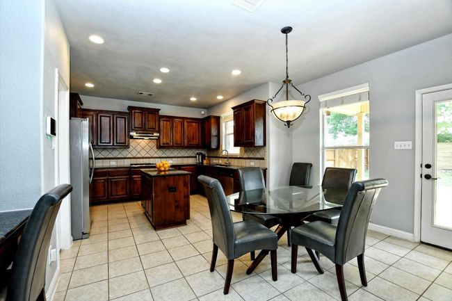 Dining space with light tile patterned floors and recessed lighting | Image 9