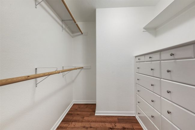 Spacious closet featuring dark wood-style flooring | Image 10