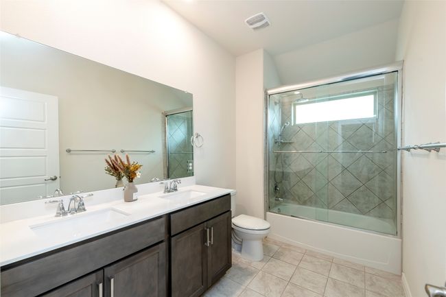 Bathroom with enclosed tub / shower combo, light tile patterned floors, and double vanity | Image 24