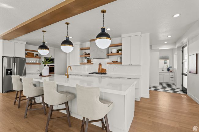Kitchen with open shelves, white cabinets, backsplash, pendant lighting, and stainless steel appliances | Image 16