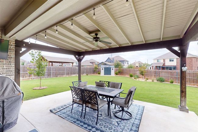View of patio with outdoor dining space, a ceiling fan, a residential view, and a grill | Image 34
