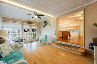 Living room featuring wooden ceiling, french doors, light hardwood / wood-style floors, crown molding, and ceiling fan | Image 3