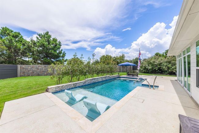 The pool is surrounded by cool decking, offering a comfortable, heat-resistant surface that enhances the inviting atmosphere. | Image 33
